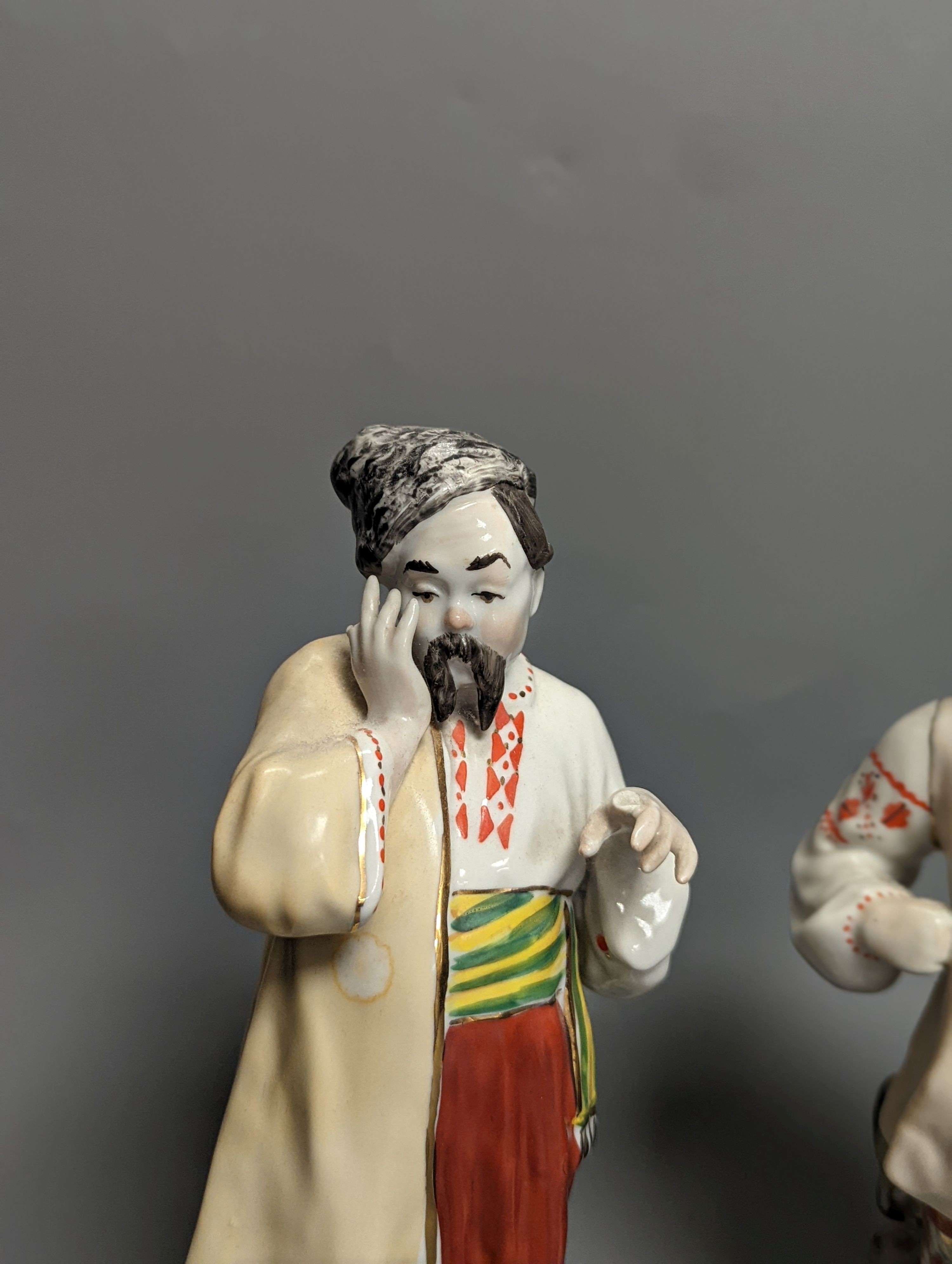 A pair of Russian porcelain figures of a Cossack and his wife 25cm